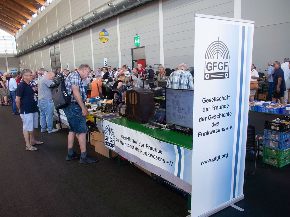 Besucher und historische Funkgeräte am Messestand der GFGF