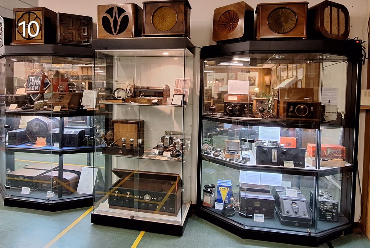 Historische Radios und Dokumente in musealen Vitrinen 2025